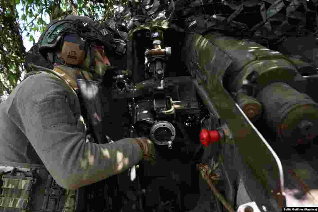 Український військовий наводить гаубицю Д-20 для ведення вогню по російських позиціях на околицях Бахмута. 11 липня 2023 року
