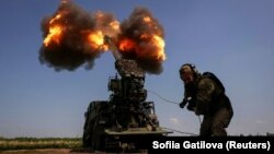 Украински военен от 57-а моторизирана пехотна бригада "Кост Гордиенко" стреля със самоходна гаубица 2S22 "Богдана" по руските войски край Бахмут, 5 юли 2023 г.