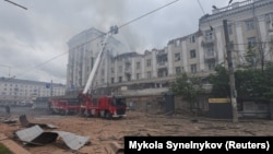 Pompierii lucrează la locul unui bloc de apartamente lovit de un atac cu rachete rusești în Dnipro pe 19 aprilie.