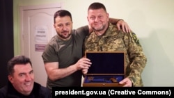 Президент України Володимир Зеленський, головнокомандувач ЗСУ Валерій Залужний (праворуч), який отримав від глава держави нагородну зброю, і секретар РНБО Олексій Данілов (ліворуч). Дніпро, 27 липня 2023 року
