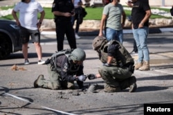 Израил аскерлери Ливандан атылган ракетанын калдыктарын текшерүүдө.
