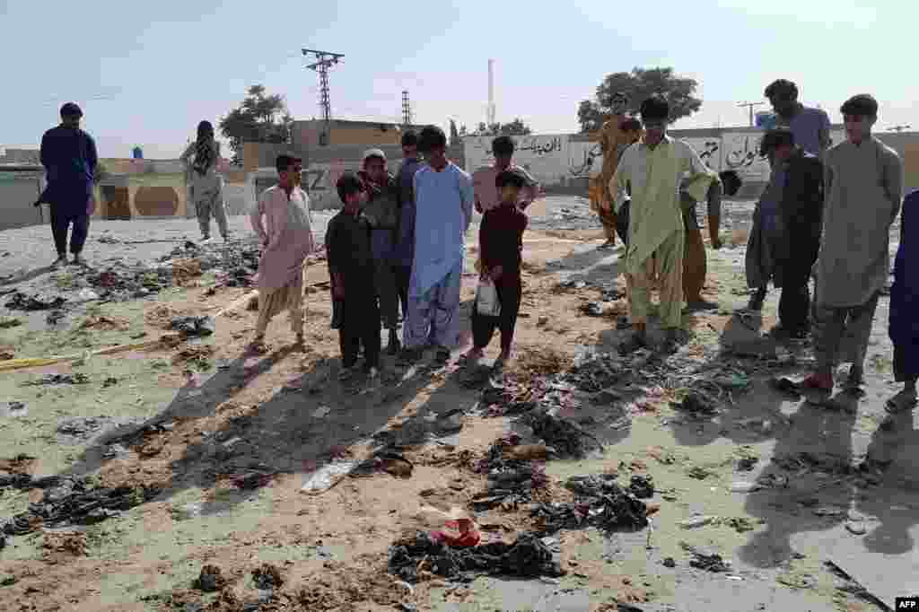 Local residents stand at the site of the suspected suicide attack where some 500 people had gathered to celebrate the Prophet Muhammad's birthday. The day is known as Mawlid al-Nabi, and is often celebrated by distributing free meals to the poor. 