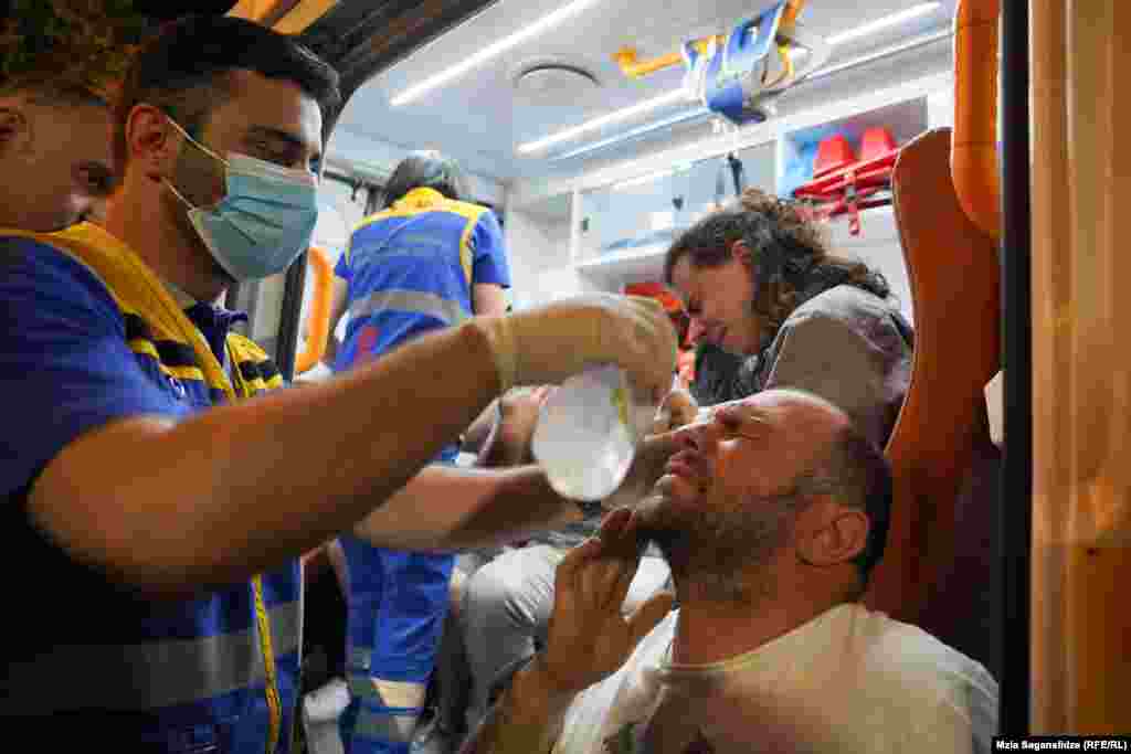 Medicii spală ochii protestatarilor care au fost expuși la gaze lacrimogene. Poliția a folosit gaze lacrimogene și spray-uri cu piper pentru a dispersa mulțimea după ce aceasta a spart liniile de securitate din apropierea clădirii parlamentului în jurul miezului nopții.