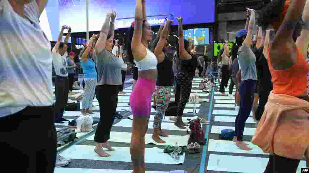 Ljudi učestvuju u "Solsticiju na Times Squareu: Mind Over Madness Yoga" , New York, 20. juna 2024. Posljednje 22 godine organizatori održavaju joga događaj na najduži dan u godini, na jednoj od najprometnijih raskrsnica na svijetu, kako bi promovirali mir i spokoj. 