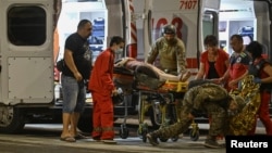 Ukrainian medical workers and servicemen treat a wounded local resident at the site of a Russian missile strike on Kryviy Rih on August 27.