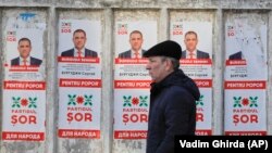 Мъж минава покрай предизборни плакати, рекламиращи кандидатите на партията Шор в Кишинев, Молдова през 2019 г. Снимката е илюстративна.