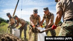 Soldați români care construiesc adăposturi anti-drone.