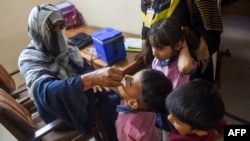 A health worker administers polio drops to a child during a door-to-door vaccination campaign in Karachi in October 2023.