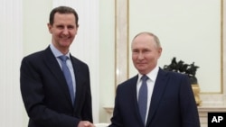 Сирийският президент Башар ал-Асад, вляво, и руският президент Владимир Путин се ръкуват по време на среща в Москва, Русия, 24 юли 2024 г.