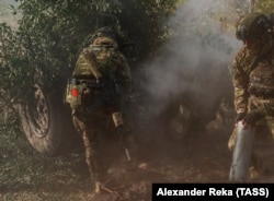Ruski vojnik s malom sovjetskom zastavom na opremi puca iz haubice u ukrajinskoj oblasti Lugansk, 4. oktobra.