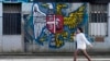 O tânără trece pe lângă o pictură murală pe un perete care prezintă o combinație dintre stema sârbă (stânga) și cea rusă, în Belgrad, Serbia. Imagine de arhivă.