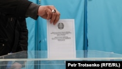 Избиратель опускает бюллетень в урну на выборах депутатов. 19 марта 2023 года