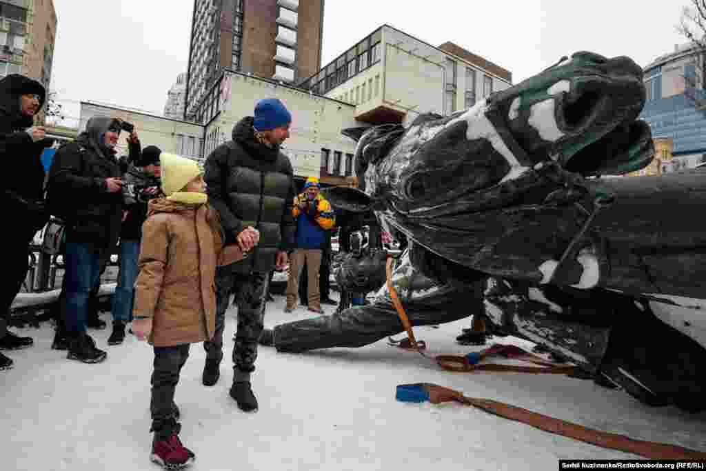 Батько показує дочці демонтований пам'ятник 