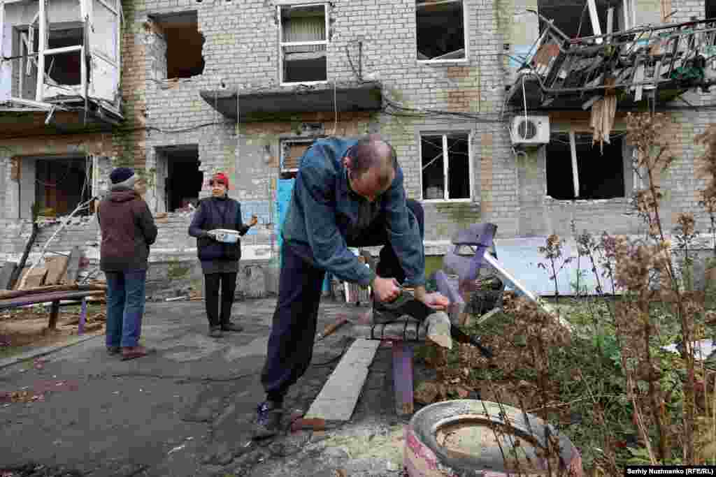 Олександър реже дърва за огрев. Въпреки че в Авдиивка има &quot;точка на непобедимост&quot; - център за хуманитарна подкрепа, предлагащ храна, топлина и убежище, вече е изключително опасно за жителите да се осмеляват да го посещават.&nbsp;