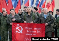 Mobilisani ruski vojni obveznici i dobrovoljci drže sovjetsku zastavu pobede dok se pripremaju za odlazak iz Orenburga, Rusija, u oktobru 2022.
