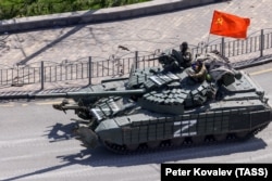 Російський танк під прапором неіснуючого СРСР в'їжджає в Маріуполь. 24 лютого 2022 року. Початок широкомасштабного вторгнення Росії в Україну