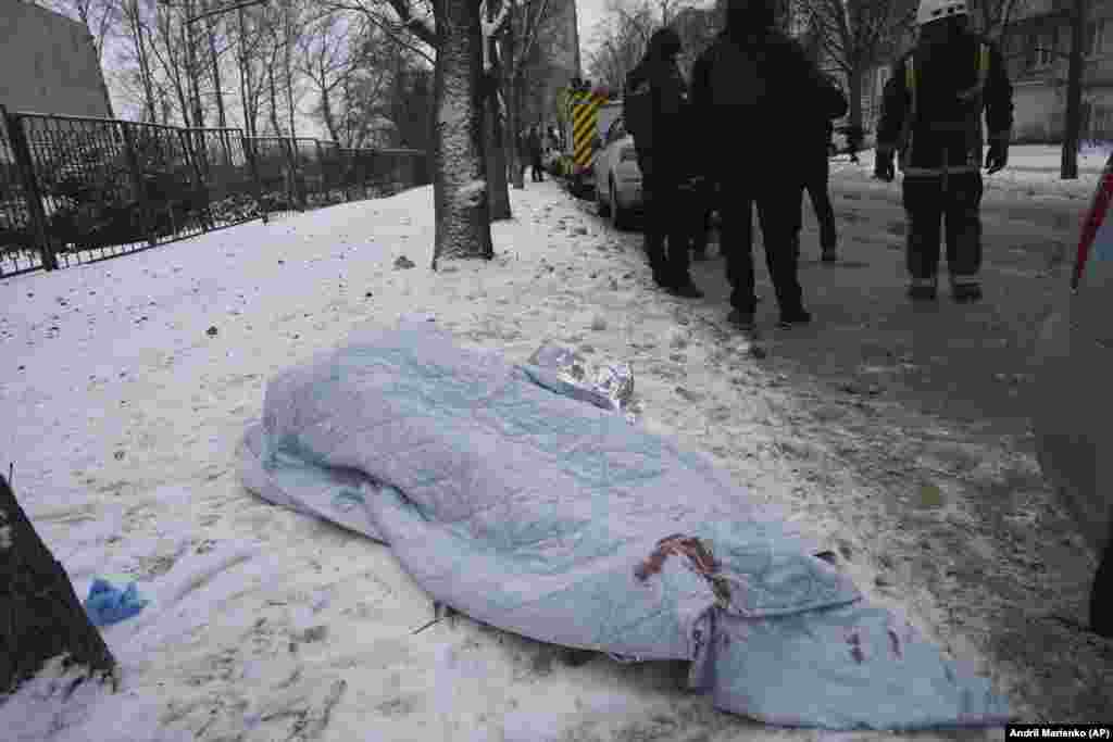 Тіло загиблого в результаті російської ракетної атаки на Харків накрите ковдрою, 23 січня 2024 року. Харків, який розташований за 30 кілометрів від кордону з Росією, часто піддається обстрілам з боку Росії, які зазвичай вражають житлові райони міста, зауважують місцеві жителі