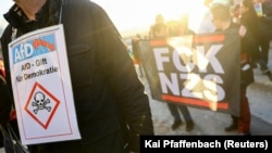 پلاکاردی که AfD را سمتی برای دموکراسی توصیف می‌کند در تجمع مخالفان در دهمین سالگرد تأسیس این حزب در فوریه ۲۰۲۳