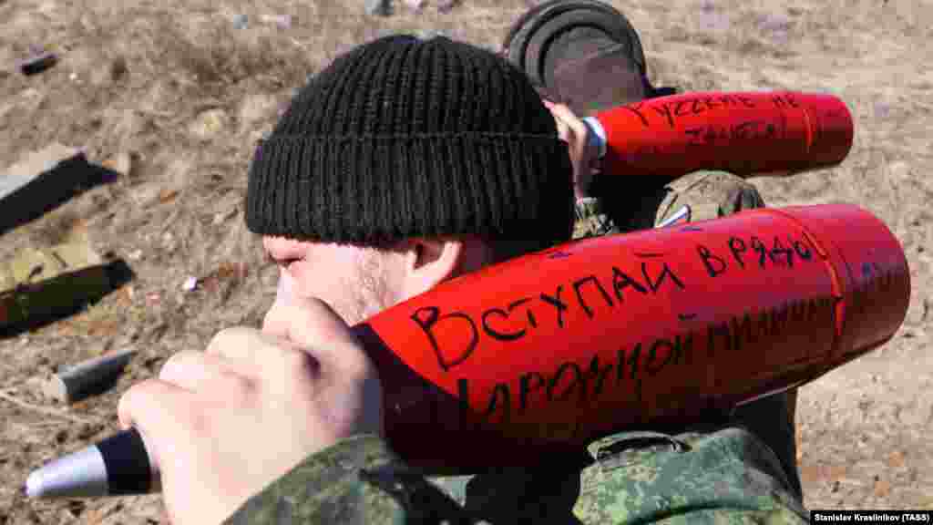 Сепаратистки бойци в окупираната част от Луганска област на Украйна се подготвят да обстрелват украински позиции със снаряди, изписани с пропагандни послания през март 2022 г. На снарядите личат надписи "Присъединете се към народното опълчение на ЛНР" и "Руснаците никога не се предават". ЛНР е абревиатурата на подкрепяната от Москва самообявила се Луганска народна република. 