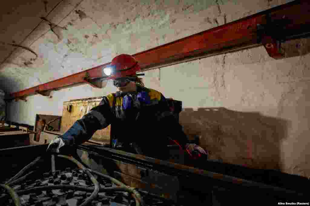 Наталья измеряет температуру батареи поезда. «Раньше я работала в магазине по продаже стиральных машин. Когда началась война, магазин закрылся. Я увидела объявление о работе и пришла на шахту. Я прошла обучение, а потом начал работать здесь», — рассказывает она 