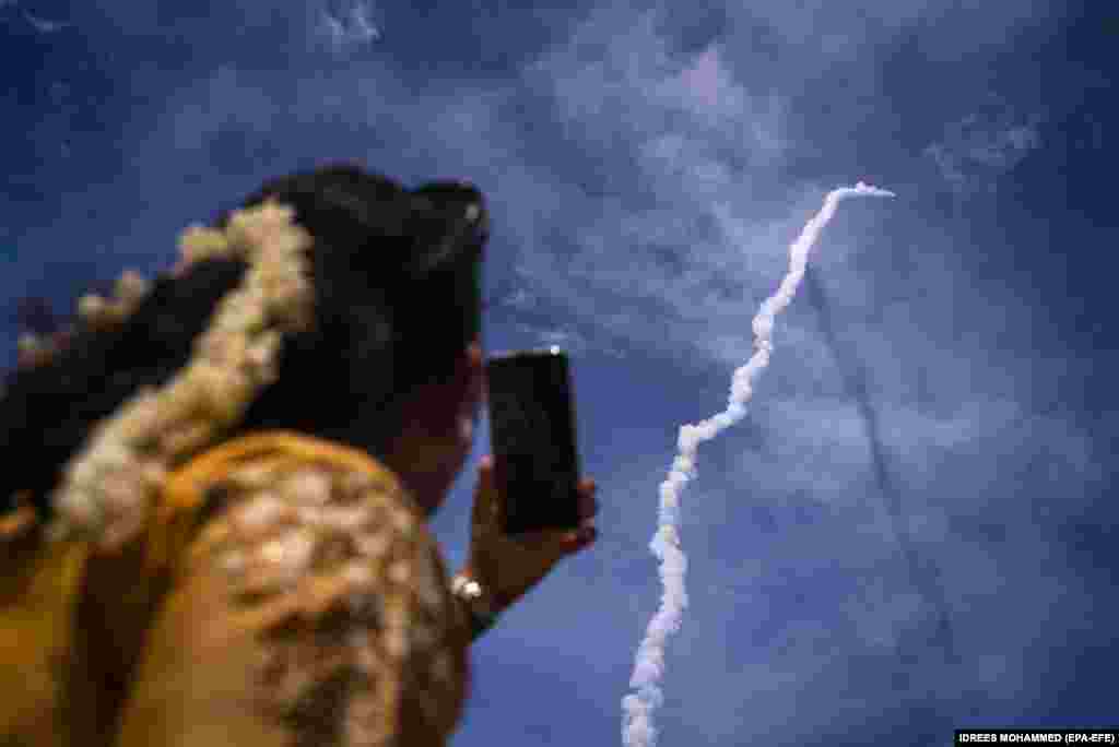Представитель общественности наблюдает, как Чандраян-3 (Лунный аппарат-3) Индийской организации космических исследований (ISRO) на борту ракеты-носителя Mark-III миссии 4 (LVM3 M4) стартует из Космического центра Сатиш Дхаван в Шрихарикота, южный штат Андхра-Прадеш. Индия, 14 июля 2023 года. Индийское космическое агентство с бюджетом менее 75 миллионов долларов пытается посадить марсоход на Луну и присоединиться к группе стран, в которую входят Соединенные Штаты, бывший Советский Союз и Китай, совершившие успешную мягкую посадку на Луну. (EPA-EFE/IDREES MOHAMMED)