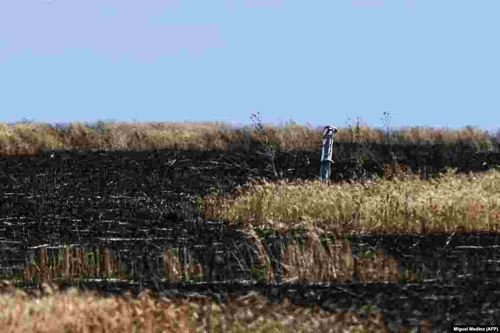 Urmele unei rachete într-un câmp de grâu, într-o zonă nespecificată din Ucraina. Din cauza blocadei navale, porturile Ucrainei de la Marea Neagră sunt inactive, ceea ce blochează rutele de aprovizionare inclusiv către națiuni africane care depind de grâul ucrainean. 