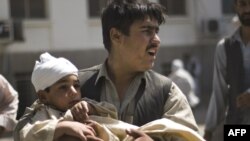 A man carries a wounded child from a Kabul hospital after the latest bombing.