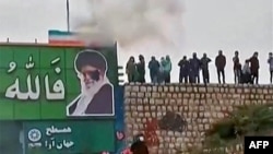 A screen grab from a video taken earlier this month that apparently shows protesters throwing a small explosive device at a banner depicting the Islamic republic's Supreme Leader Ayatollah Ali Khamenei in the central city of Isfahan.