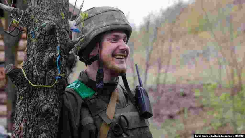 Військовий посміхається, коли один із його побратимів розповідає історію з життя. Донецька область, 22 квітня 2022 року
