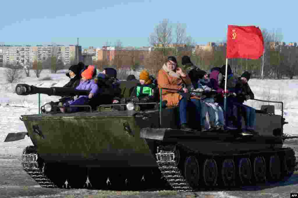 Көңүл ачуу паркында аскердик машинеде бараткан кишилер. Орусия, Ленинград облусу. Гатчина шаары. 6-март, 2022-жыл.