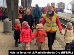 Волонтери зустрічають дітей-сиріт на пероні і супроводжують їх до автобусів