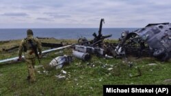 Український військовий на острові Зміїний у Чорному морі біля знищеного раніше російського гелікоптера, 18 грудня 2022 року, ілюстративне фото