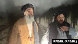 Two men walk away from the scene of the explosion in the Salang Tunnel, located about 130 kilometers north of Kabul, on December 18.