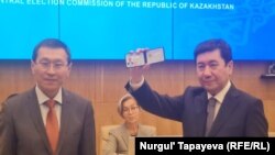 Председатель партии «Аманат» Ерлан Кошанов получает удостоверение кандидата в президенты, врученное Касым-Жомарту Токаеву. 12 октября 2022 года