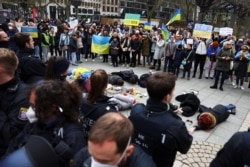 Ofițeri de poliție stau de pază în timp ce susținători ai Ucrainei iau parte la un protest împotriva unei demonstrații pro-ruse, în Frankfurt, Germania, 10 aprilie 2022.