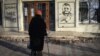 Літня жінка дивиться на графіті із зображенням головнокомандувача ЗСУ Валерія Залужного та написом «З нами Бог і отаман Залужний» у центрі Бахмуту, що на Донеччині, 20 грудня 2022 року