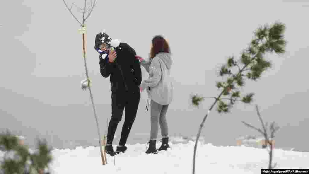 Ova fotografija mladog para, od 24. decembra, koji se igra sa snijegom na vrhu brda iznad Teherana, jedna je od nekoliko nedavnih slika koje prikazuju iranske žene u javnosti bez hidžaba, pokrivala za glavu koje je obavezno za žene u Iranu od 1983. godine.