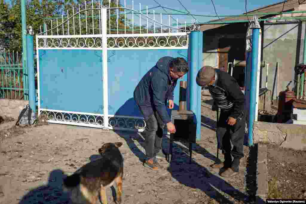 Șeful unui consiliu local îi explică unui locuitor din Prîbuzke, în apropierea frontului de luptă, cum funcționează sobele. Proiectarea sobelor se bazează pe modele existente, „doar că au fost îmbunătățite puțin pentru a fi ușor de utilizat și mai ieftine de produs”, spune Ramestam. 
