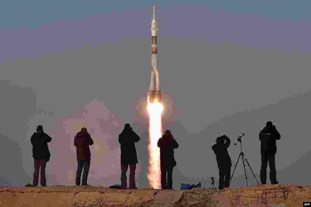 Фотографы снимают запуск с Байконура 15 декабря ракеты с российским кораблем "Союз", который доставит на орбиту новый экипаж в составе российского космонавта и астронавтов из США и Великобритании.