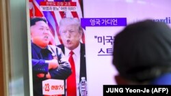 Түштүк Кореялык адам Трамп менен Ким Чен Ын тууралуу телеберүүнү көрүп отурат.