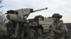 A Ukrainian serviceman stands next to a Caesar 8x8 wheeled self-propelled howitzer on a frontline in an undisclosed location, Southern Ukraine on February 14, 2024,