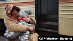 Майка прегръща дъщеря си, след като пристигат с влак от Харков в Лвов. 4 март 2022.