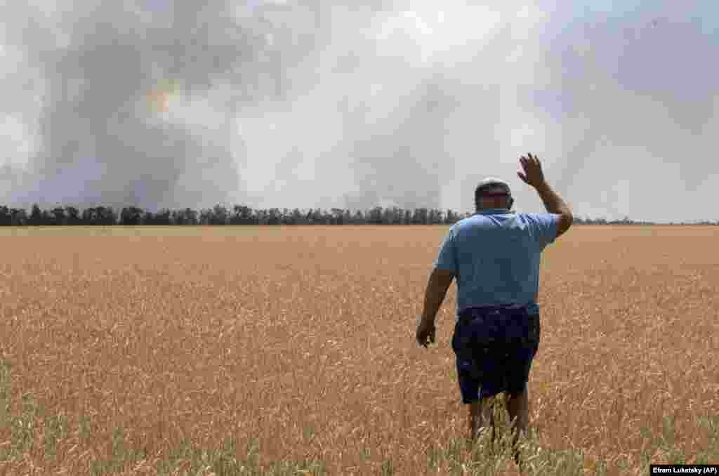 Un fermier ucrainean din regiunea Dnipro urmărește cum arde câmpul său de grâu în urma luptelor din 4 iulie. 