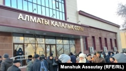 Десятки человек собрались перед зданием Алматинского городского суда, чтобы поддержать 13 активистов, апелляции которых рассматривает суд. Алматы, 28 декабря 2021 года