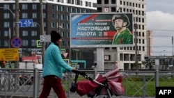 Un panou publicitar din Sankt Petersburg care promovează serviciul militar cu imaginea unui soldat și un slogan care spune: „A servi Rusia este o slujbă adevărată”.