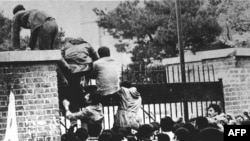 Iranian students climb over the wall of the U.S. Embassy in Tehran on November 4, 1979.