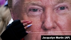 Sve je duži spisak dojučerašnjih saradnika predsednika SAD koji podnose ostavke nakon upada njegovih nasilnih pristalica u zgradu Kongresa u Vašingtonu. Na slici, pristalica Donalda Trampa drži njegovu fotografiju na protestu koji je prethodio upadu u Kongres 6. januara 2021. 