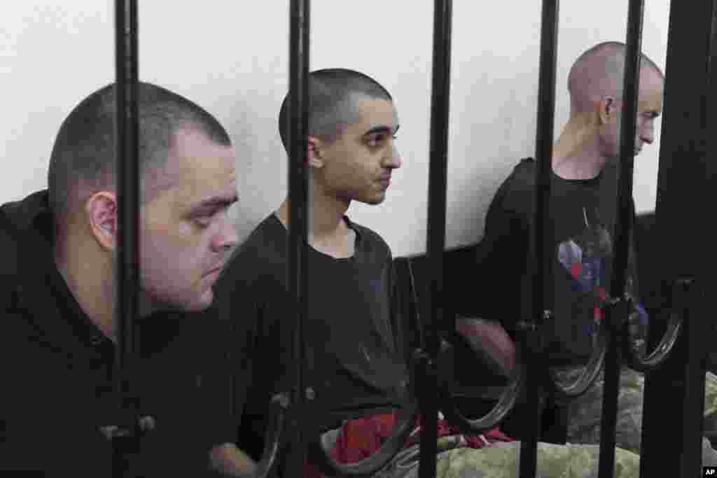 Громадяни Великої Британії Ейден Еслін та Шон Піннер і марокканець Брагім Саадун під час так званого «суду» в окупованому Донецьку 9 червня 2022 року, де угруповання «ДНР» винесло їм смертні вироки 
