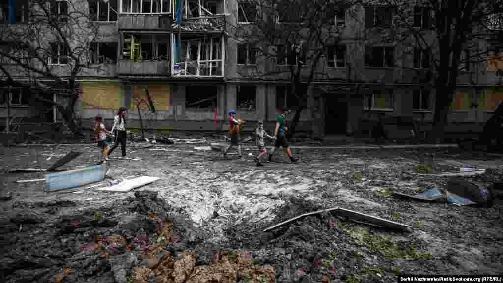 Grupa dece prolaze pored ruševina koje su ostale nakon raketnog udara. Bahmut se nalazi 55 kilometara jugozapadno od gradova Lisičansk i Sjeverodonjeck, gde se dešavaju žestoki vojni sukobi, a koje je Kijev opisao kao "jednu od najkrvavijih bitaka u, kao i za Evropu". 