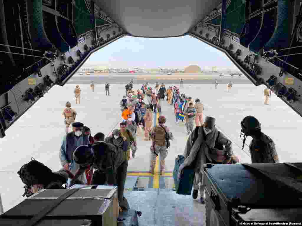Cetățeni afgani și spanioli se îmbarcă într-un avion militar pentru a fi evacuați, pe Aeroportul Internațional Hamid Karzai din Kabul, Afganistan, 18 august 2021. &nbsp;